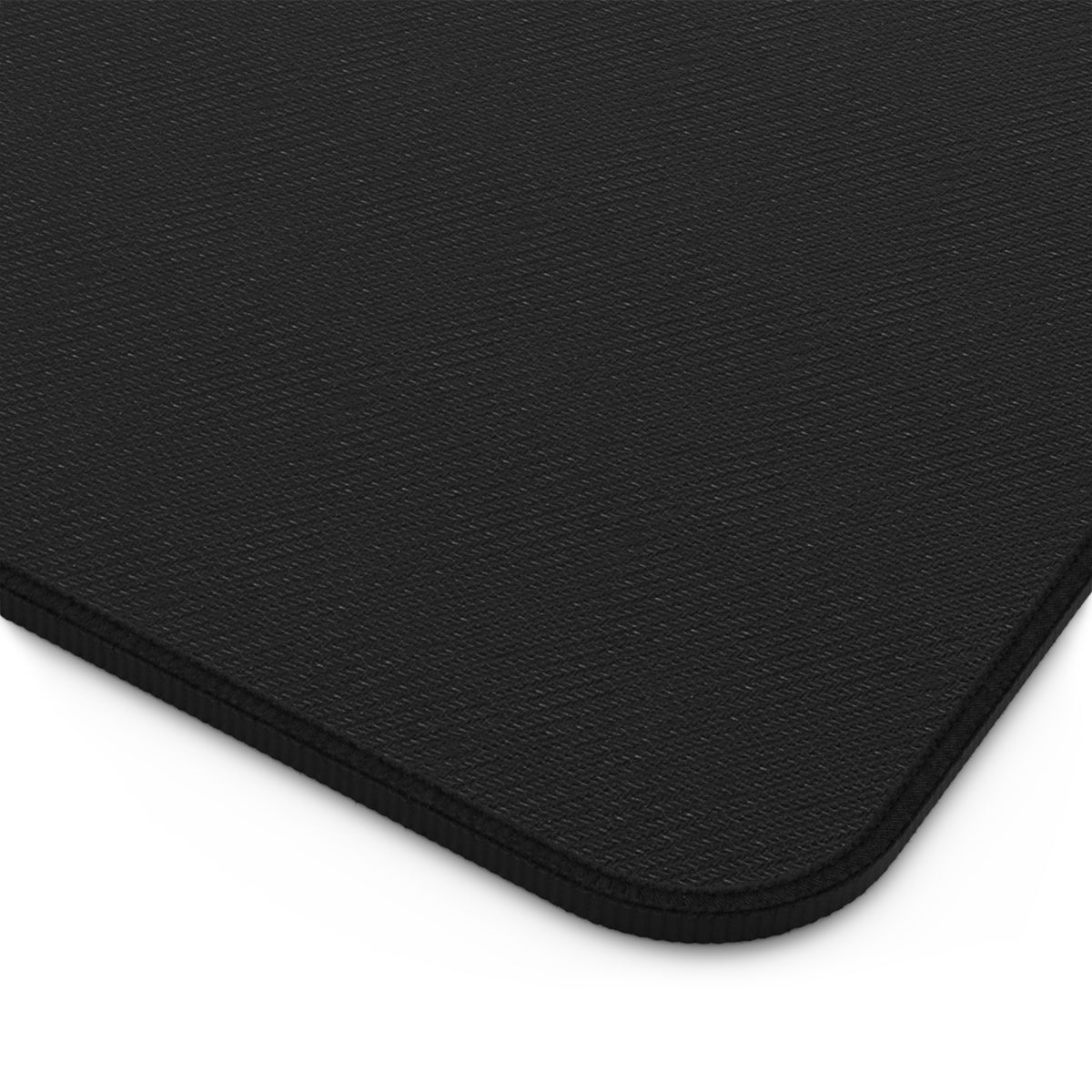 Close-up of the black fabric backing, stitched binding, and rounded corner of the Gothic Reaper Castle desk mat.