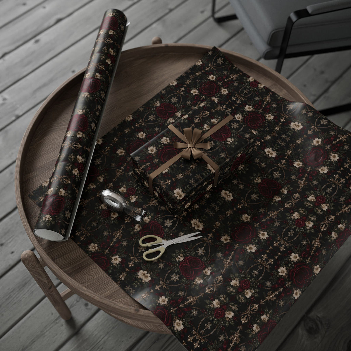 Midnight Floral Medallion wrapping paper arranged with a wrapped present and rolled sheet on a round tray, with scissors and tape nearby.