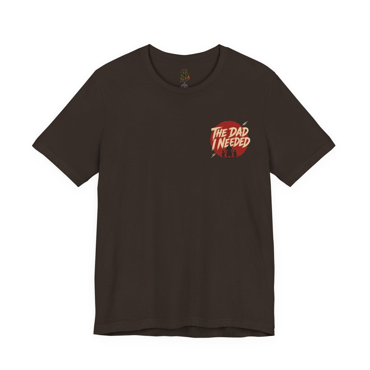 Built Different Tee dark brown front flat-lay — The Dad I Needed red circle left chest badge with SD monogram neck label