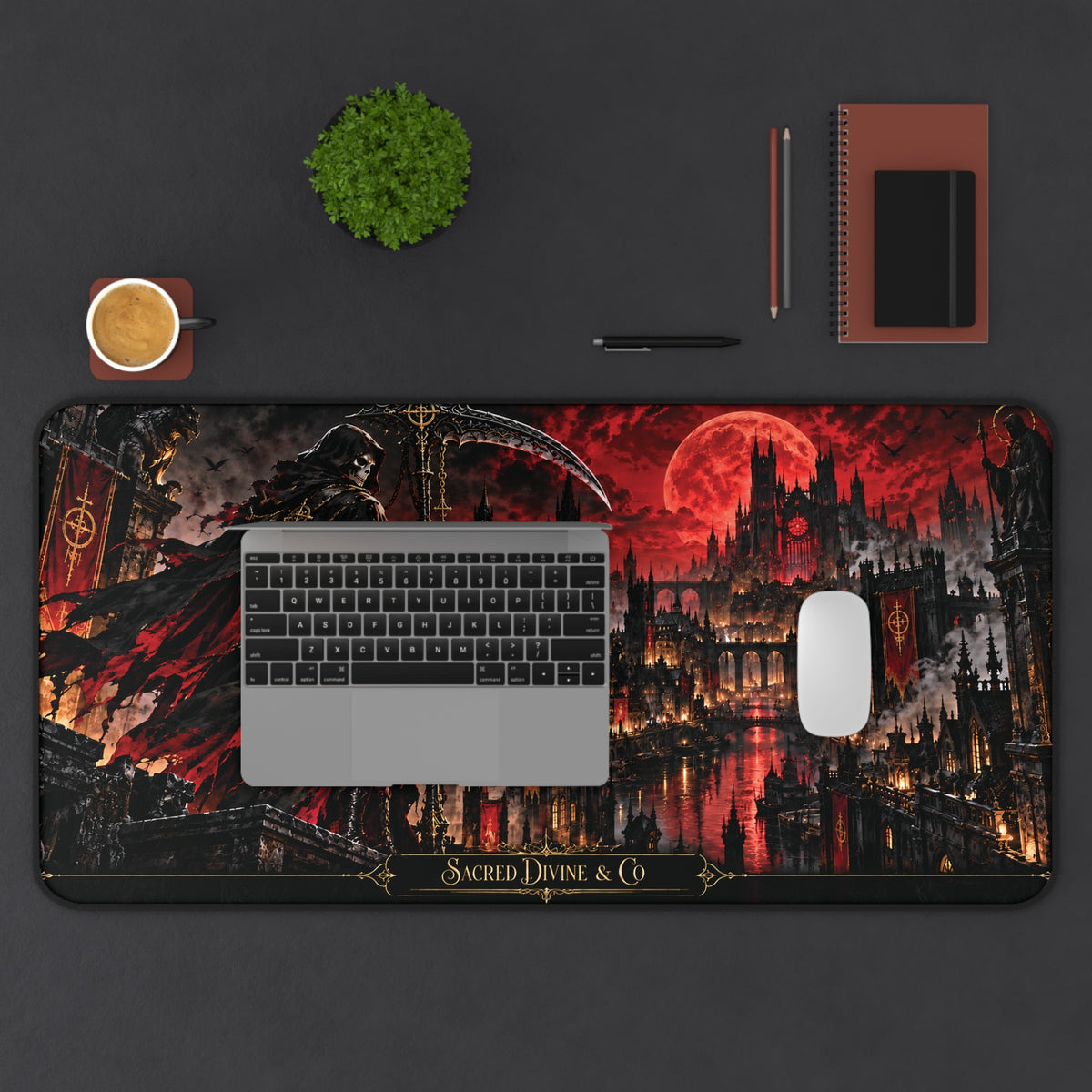 Gothic Reaper Castle desk mat showing grim reaper and dark castle beneath a crimson moon, arranged horizontally on a desk beneath a laptop with a mouse, plant, cup, and notebook.