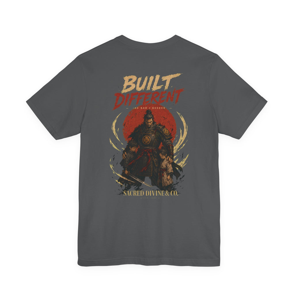 Built Different Tee charcoal back flat-lay — Built Different The Dad I Needed warrior crest full back graphic and Sacred Divine & Co. wordmark