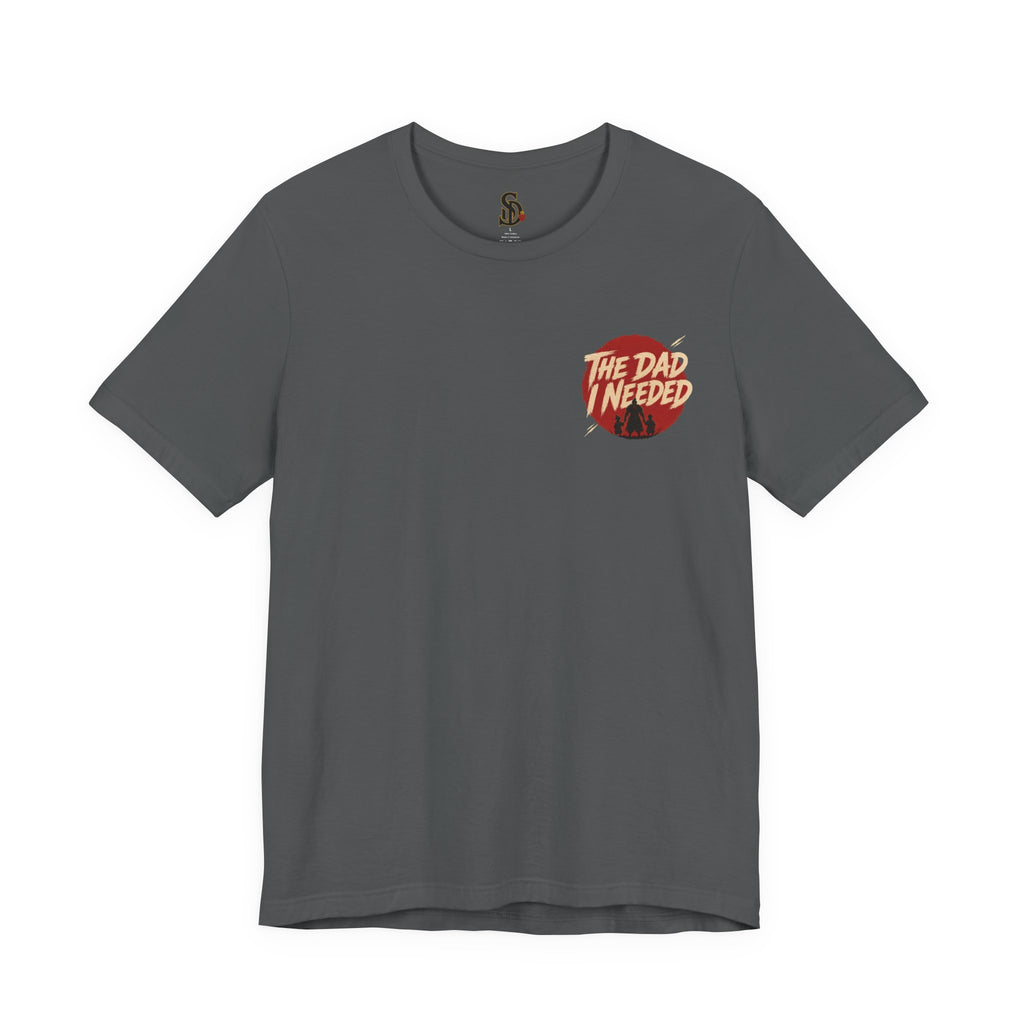 Built Different Tee charcoal front flat-lay — The Dad I Needed red circle left chest badge with SD monogram neck label