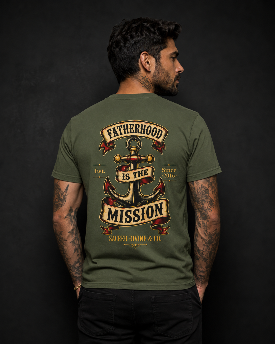 Fatherhood Is the Mission Tee military green back lifestyle — model wearing tee with Fatherhood Is the Mission vintage anchor banner full back graphic and Sacred Divine & Co. wordmark