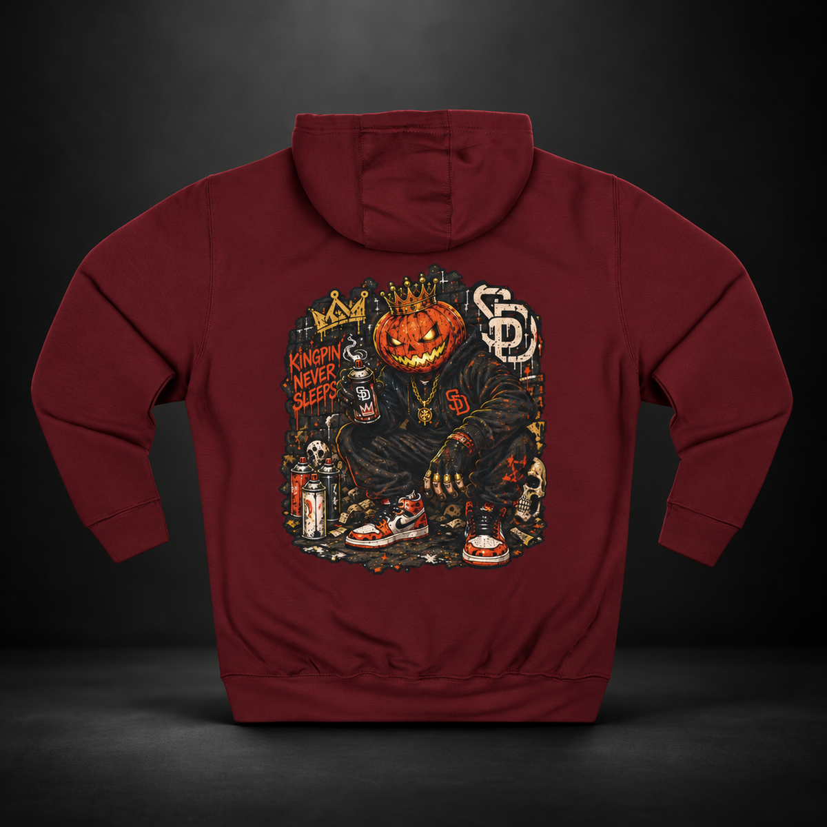 Burgundy Pumpkin King Hoodie, back view against a dark backdrop with a crowned jack-o'-lantern streetwear character and Kingpin Never Sleeps lettering.